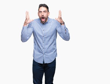 Yakışıklı delikanlı deli kutluyor ve silah ile başarı için heyecanlı çığlık kaldırdı ve açık gözleri hayret izole arka plan üzerinde. Kazanan kavramı