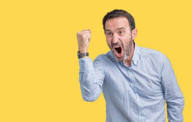 Yakışıklı orta yaş izole arka plan öfkeli ve sinirli sinirli ve öfke ile bağırarak süre öfkeli yumruk yükselterek üzerinde zarif komuta sizde. Öfke ve agresif kavramı.