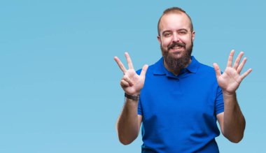 Genç beyaz hipster giyiyor mavi gömlek uzun kol üzerinde gösterilen arka plan izole ve parmakları ile işaret gülümseyen ise kendinden emin ve mutlu 8 numaralı.