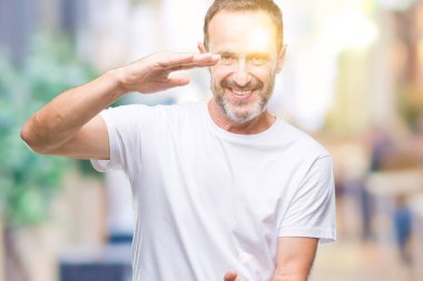 Orta yaş ağarmış komuta sizde üzerinde beyaz t-shirt giyen arka plan ile büyük ve büyük boy işaret, ölçü birimi sembol gösteren el eller izole. Kameraya bakarak gülümsüyordu. Ölçüm kavramı.