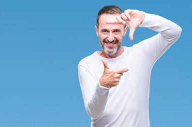 Elle yapma çerçeve ve parmakları ile mutlu yüz gülümseyen izole arka plan üzerinde beyaz t-shirt giyen orta yaş ağarmış komuta sizde. Yaratıcılık ve Fotoğrafçılık kavramı.