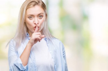 Genç Sarışın kadın dudaklarında parmak ile sessiz olmanı izole arka plan yüzünden. Sessizlik ve gizli kavramı.