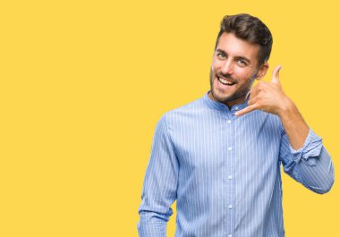 Yakışıklı delikanlı yapıyor gülümseyen izole arka plan üzerinde telefon hareketi ile el ve parmak telefonda konuşuyor gibi. Kavramları iletişim.