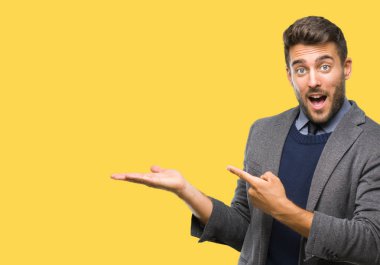 Genç yakışıklı iş adamı üzerinden hayran ve el ile sunulması ve parmak ile işaret ederken kameraya gülümseyen izole arka plan.