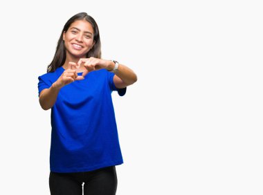 Genç güzel Arap kadın kalp simgesi ve elleriyle şekil gösterilen aşık gülümseyen izole arka plan yüzünden. Romantik kavramı.