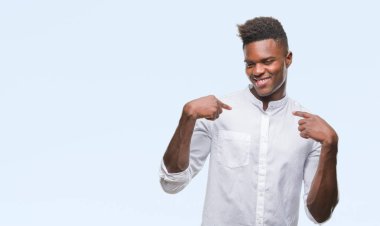 Yüzünde gülümseme ile kendinden emin görünüyorsun, kendini gururlu ve mutlu parmakları ile işaret izole arka plan üzerinde genç Afro-Amerikan adam.