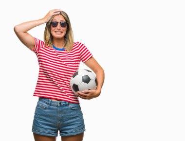 Baş, el ile vurguladı izole arka plan üzerinde futbol futbol topu tutan genç güzel kadın şok utanç ve sürpriz suratla, öfkeli ve sinirli. Korku ve hata için üzgün.