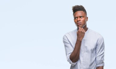 Afrikalı-Amerikalı genç çene düşünme hakkında soru, dalgın ifade üzerine el ile izole arka plan üzerinde. Düşünceli yüzüyle gülümsüyor. Şüphe kavramı.