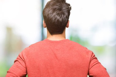 Geriye doğru uzakta silah ile vücut üzerinde seyir izole arka plan ayakta genç yakışıklı adam