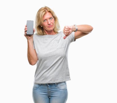 Orta yaş sarışın kadın gösteren boş ekran smartphone kızgın yüzü, eksi işareti aşağı antipati başparmak ile gösterilen, ret kavramı ile izole arka plan üzerinde