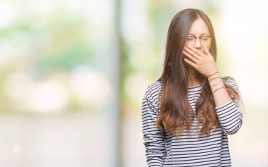 İzole arka plan üzerinde gözlüklü Genç Asyalı kadın el ağzıyla kapsayan yorgun esneme sıkılmış. Restless ve uyku hali.
