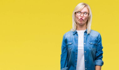 İzole arka plan yapma balık yüzüne dudaklı, çılgın ve komik bir jest gözlüklü genç güzel sarışın bir kadın. Komik ifade.