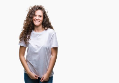 Güzel esmer kıvırcık saçlı Genç kız üzerinde rahat t-shirt giyen arka yüzünde mutlu ve güzel bir gülümseme ile izole. Şanslı kişi.
