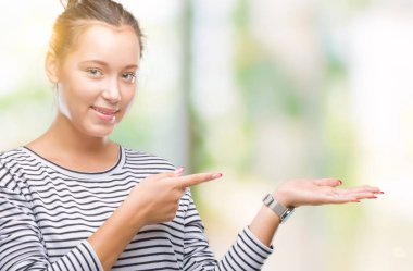 Genç güzel beyaz kadın üzerinden hayran ve el ile sunulması ve parmak ile işaret ederken kameraya gülümseyen izole arka plan.