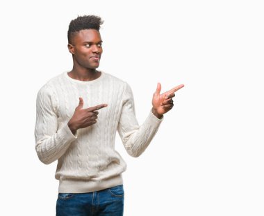 Gülümseyen ve iki elleri ve parmakları ile tarafına işaret kamera bakarak izole arka plan üzerinde genç Afro-Amerikan adam.