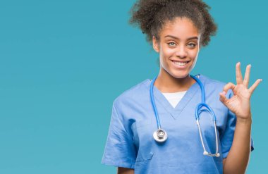 İzole arka plan el ve parmaklar ok işaretiyle yapıyor olumlu gülümseyen üzerinde genç afro Amerikalı doktor kadın. Başarılı ifade.