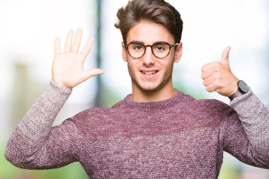 Gösterilen arka plan üzerinde gözlük takan genç yakışıklı adam izole ve parmakları ile işaret kendinden emin ve mutlu gülümseyerek süre 6 numara.