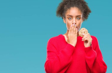 Hata, korku, sessizlik içinde gizli kavramı korkmuş ifade için utanç ile genç afro Amerikalı kadın izole arka kapak ağız el ile üzerinden çikolatalı kurabiye yemek şok