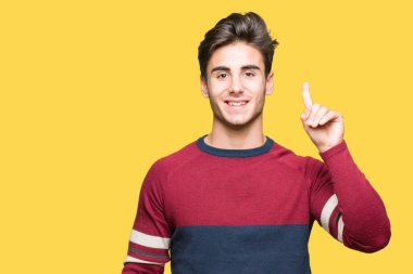 Yakışıklı delikanlı gösterilen ve kendinden emin ve mutlu gülümseyen bir parmak ile işaret eden oktan yukarı izole arka plan üzerinde.