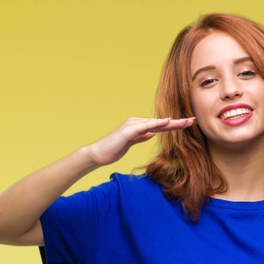 İzole edilmiş arka planda genç ve güzel bir kadın. Elleri büyük ve büyük bir işaret, ölçü sembolü gösteriyor. Kameraya bakıp gülümsüyor. Ölçüm konsepti.