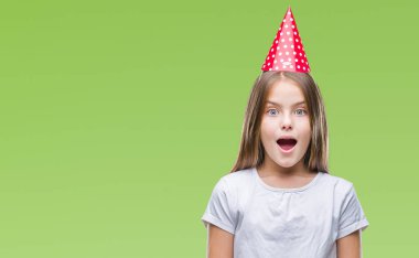 Genç güzel kız korkuyor ve şok sürpriz ifade, korku ve heyecan yüz ile izole arka plan üzerinde Doğum günü şapkası.