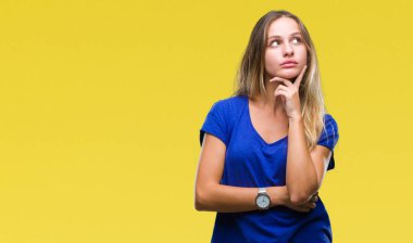 Genç güzel sarışın kadın elle çene düşünme hakkında soru, dalgın ifade izole arka plan yüzünden. Düşünceli yüzüyle gülümsüyor. Şüphe kavramı.