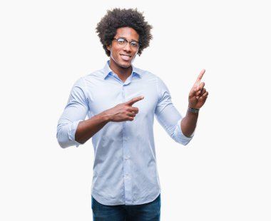 Gülümseyen ve iki elleri ve parmakları ile tarafına işaret kamera bakarak izole arka plan üzerinde gözlük takan Afro Amerikalı iş adamı.