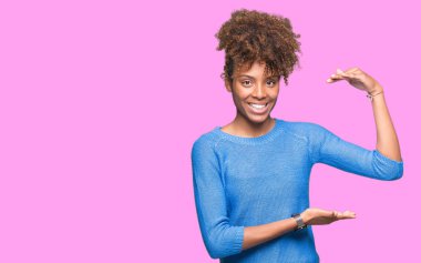 Güzel genç Afro-Amerikan kadın ile büyük ve büyük boy işaret, ölçü birimi sembol gösteren el eller izole arka plan yüzünden. Kameraya bakarak gülümsüyordu. Ölçüm kavramı.