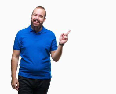 Yüzünde kocaman bir gülümseme ile izole arka plan üzerinde mavi gömlek giymiş genç beyaz hipster adam kameraya bakarak yan el ve parmak ile işaret.