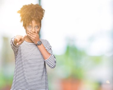 Güzel genç Afro-Amerikan kadın gözlük izole üzerinde gülme sizin parmak el kamerasıyla ağzına, utanç ifadesi işaret eden arka plan