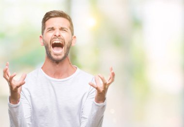 Genç yakışıklı adam izole arka plan çılgın ve kızgın bağırarak ve agresif ifade ve silah kaldırdı bağırıyor. Hayal kırıklığı kavramı.