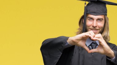 Genç yakışıklı adam uzun saçlı aşık kalp simgesi ve elleriyle şekil gösteren gülümseyen izole arka plan üzerinde mezun oldu. Romantik kavramı.