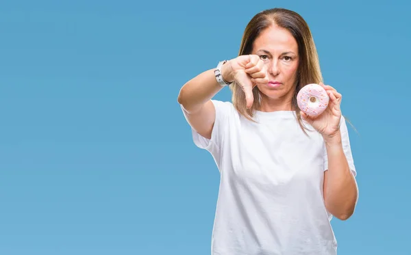 怒った顔 ダウン親指で嫌悪感を示すマイナス記号 拒絶反応の概念と分離の背景にピンクのドーナツを食べる中年ヒスパニック系女性 — ストック写真
