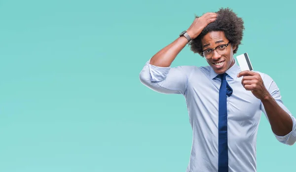 Hombre Afroamericano Sosteniendo Tarjeta Crédito Sobre Fondo Aislado Estresado Con —  Fotos de Stock