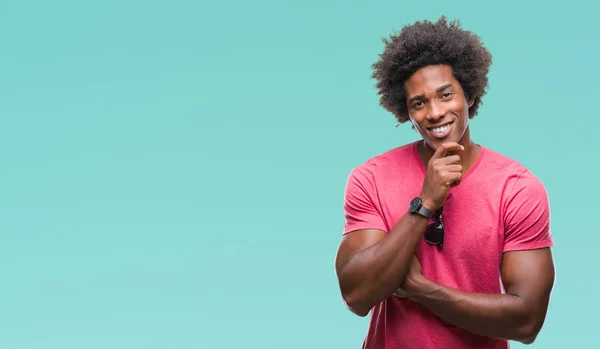 Afro american man over isolated background looking confident at the camera with smile with crossed arms and hand raised on chin. Thinking positive.