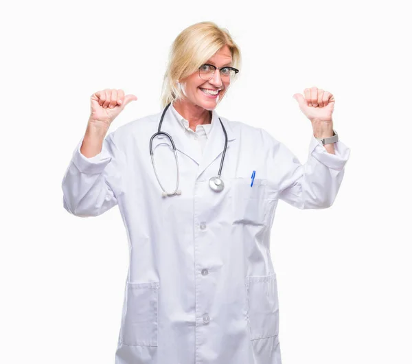 中年金发医生妇女在孤立的背景看起来自信与微笑在脸上 指着自己与手指自豪和快乐 — 图库照片