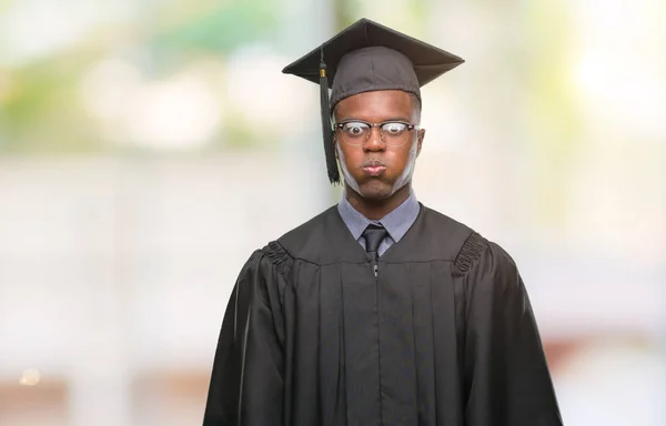 Young graduated african american man over isolated background puffing cheeks with funny face. Mouth inflated with air, crazy expression.