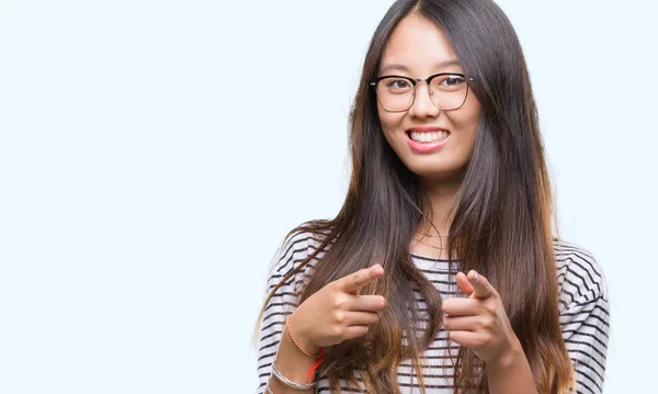 若いアジアの女性は 幸せと面白い顔でカメラに指を指して孤立の背景にメガネを着用します 良いエネルギーとヴァイブス — ストック写真