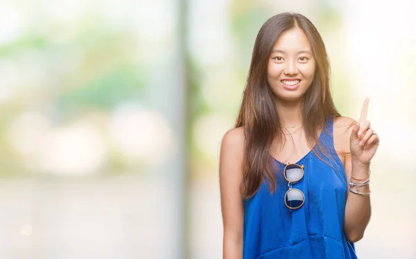 Young Asian Woman Isolated Background Showing Pointing Finger Number One — Stock Photo, Image