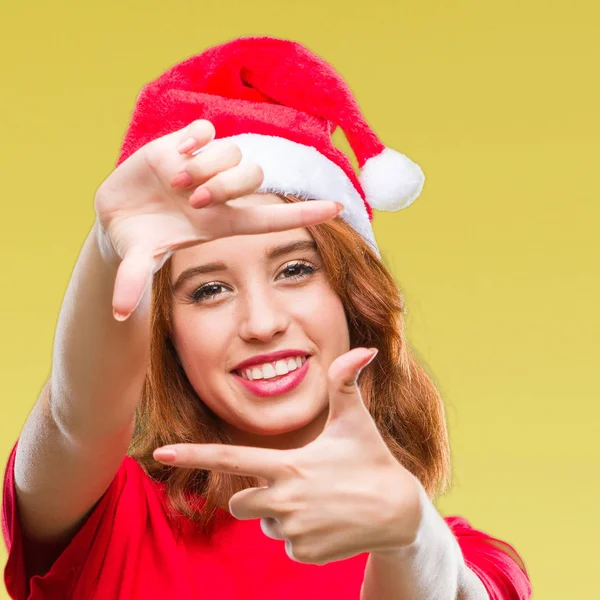 笑顔の幸せそうな顔で指と手作りフレーム クリスマス帽子をかぶっている孤立した背景に若くてきれいな女性 創造性と写真のコンセプト — ストック写真