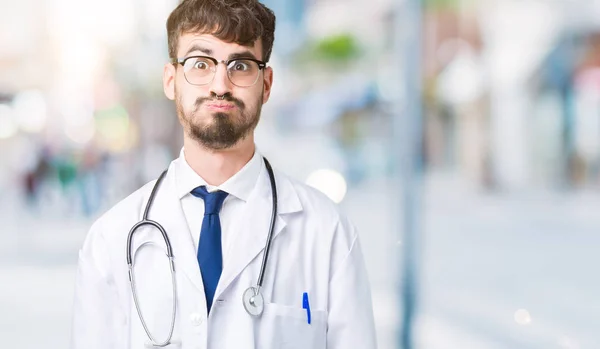 年轻的医生穿在孤立的背景膨胀脸颊与滑稽的脸的医院外套 嘴被空气膨胀 疯狂的表情 — 图库照片