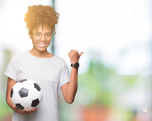 Jovem Afro Americana Segurando Bola Futebol Sobre Fundo Isolado Apontando — Fotografia de Stock