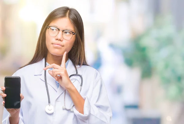 Jovem Asiático Médico Mulher Segurando Smartphone Sobre Isolado Fundo Sério — Fotografia de Stock