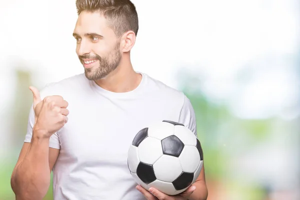Молодой Человек Держит Футбольный Мяч Изолированном Фоне Указывая Показывая Пальцем — стоковое фото