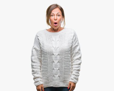 Orta yaş İspanyol kadın kıdemli giyen kış kazak korkuyor ve şok sürpriz ifade ile izole arka plan üzerinde korku ve yüz heyecanlı.