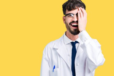 El yüz ve sürpriz duygu kendinden emin gülümseme ile tek gözüyle kapsayan izole arka plan üzerinde beyaz önlük giyen genç profesyonel bilim adamı.