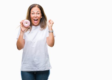 Duygu tezahürat gurur çığlık ve zafer ve başarı çok heyecanlı, kutluyor izole arka plan üzerinde pembe çörek yemek orta yaş İspanyol kadın