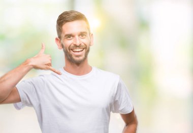 Yakışıklı delikanlı yapıyor gülümseyen izole arka plan üzerinde telefon hareketi ile el ve parmak telefonda konuşuyor gibi. Kavramları iletişim.