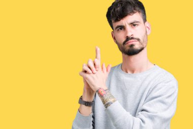 El hareketi ile sembolik silah tutan, çekim silah, kızgın yüz öldürmek oynamaya izole arka plan üzerinde sweatshirt giyen genç yakışıklı adam