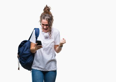 Sırt çantası, kulaklık ve akıllı telefon gurur çığlık ve zafer ve başarı çok heyecanlı, kutluyor izole arka plan üzerinde giyen genç esmer öğrenci kız duygu tezahürat